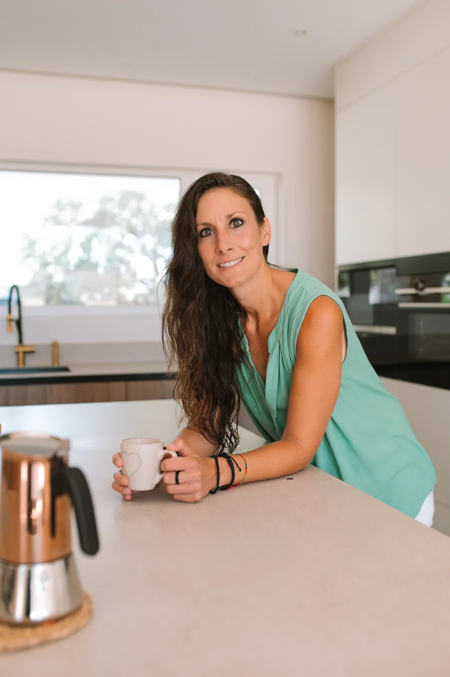Ana Pedroche apoyada en la encimera de su cocina, con una taza y una cafetera
